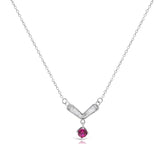 Silver necklace with a V-shaped pendant and red gemstone on a white background