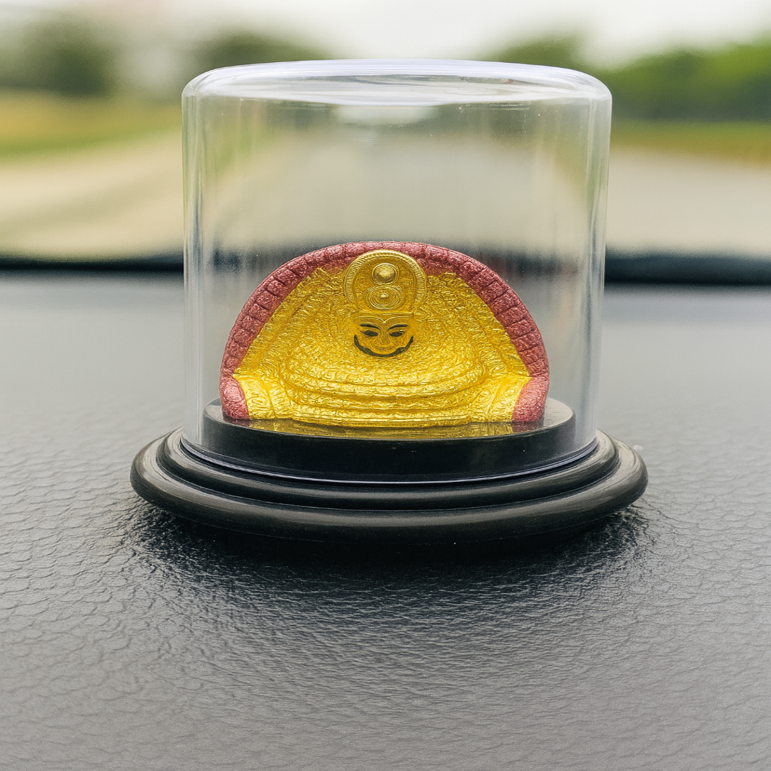 Yellow and red object in a glass dome on a black surface with blurred green background
