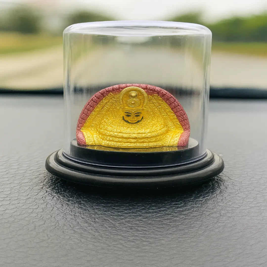 Yellow and red object in a glass dome on a black surface with blurred green background