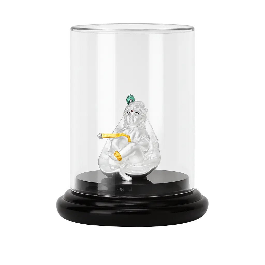 Glass display case with a figurine of a seated figure holding a staff on a white background