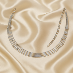 Silver necklace on a beige satin background