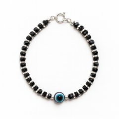 Black beaded bracelet with a blue evil eye charm on a white background