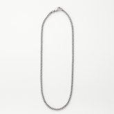 Silver chain necklace on a light gray background