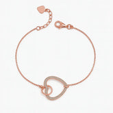 Rose gold bracelet with a heart charm on a white background