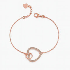 Rose gold bracelet with a heart charm on a white background