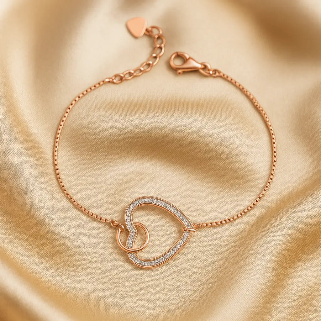 Rose gold bracelet with heart design on a beige fabric background