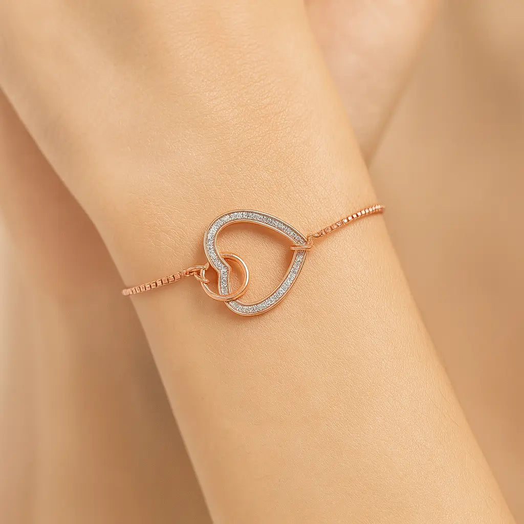 Rose gold bracelet with heart design on a wrist against a beige background