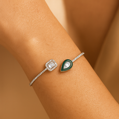 Two diamond-encrusted bracelets on a person's wrist against a beige background