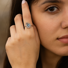 Close-up of a woman wearing a decorative ring on her finger.