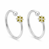 A pair of silver-toned open hoop earrings with a small flower charm in olive green and pale yellow enamel, shown on a clean white background.