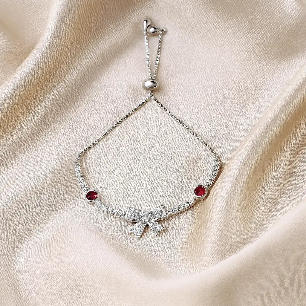 Silver bracelet with red gemstones on a beige fabric background