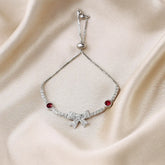 Silver bracelet with red gemstones on a beige fabric background