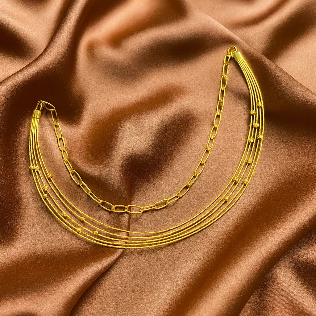 Gold chain necklace on brown satin fabric
