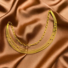 Gold chain necklace on brown satin fabric