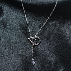 Silver necklace with a pendant on a dark fabric background