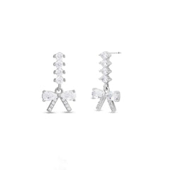 Silver bow-shaped earrings with clear gemstones on a white background