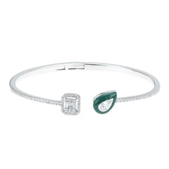 Silver bracelet with a square-cut gem and a teardrop-shaped green gem on a white background