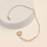 Pearl bracelet with gold clasp on a light beige background