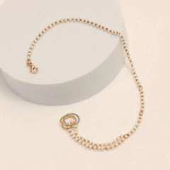 Pearl bracelet with gold clasp on a light beige background