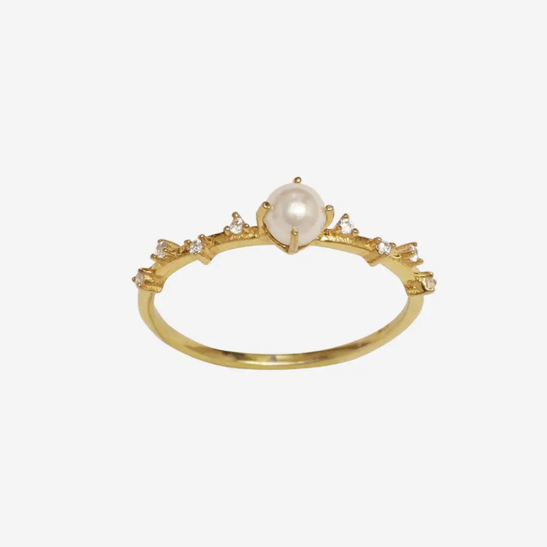 Gold ring with a pearl and small diamonds on a white background