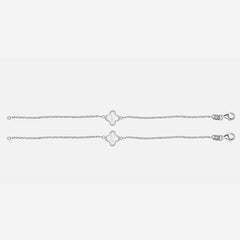 Silver anklets with clover-shaped charms on a light gray background