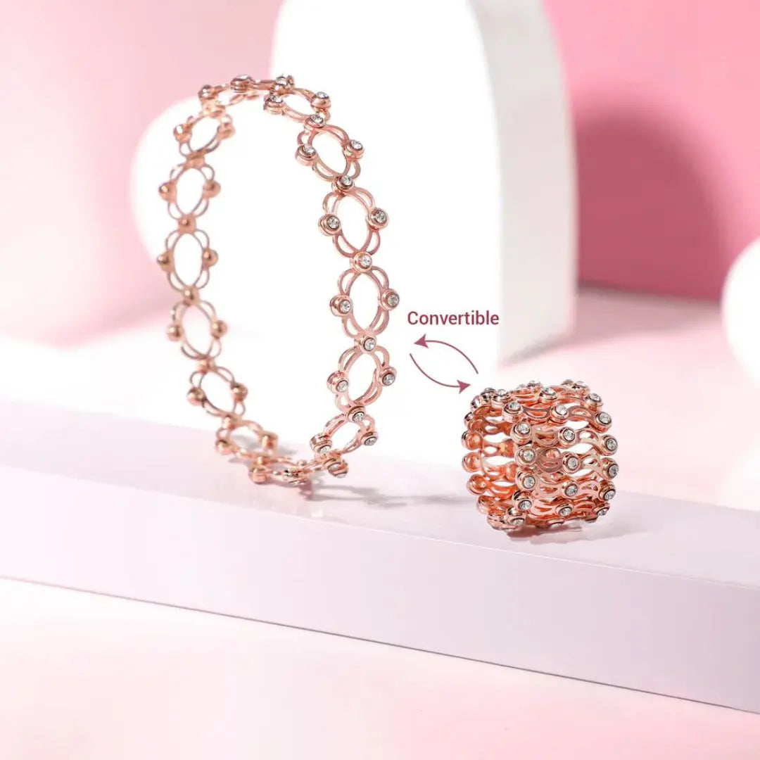Rose gold bracelet and ring set on a pink background