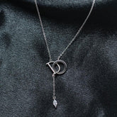 Silver necklace with a pendant on a dark fabric background