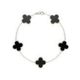 Silver bracelet with black clover-shaped charms on a white background