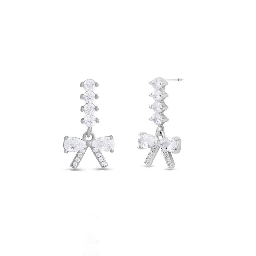Silver bow-shaped earrings with clear gemstones on a white background