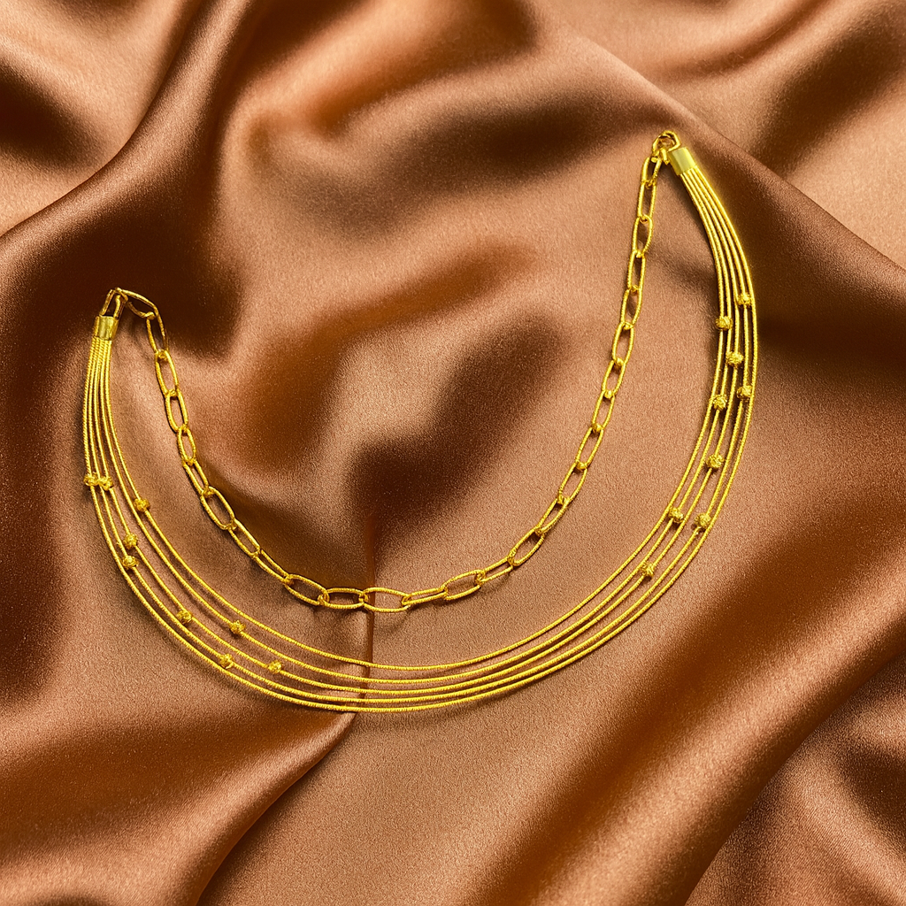 Gold chain necklace on brown satin fabric