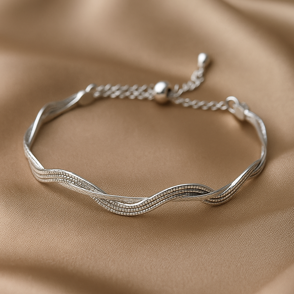 Silver bracelet with wavy design on a beige fabric background