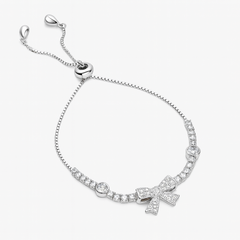 Silver bracelet with bow charm on a white background