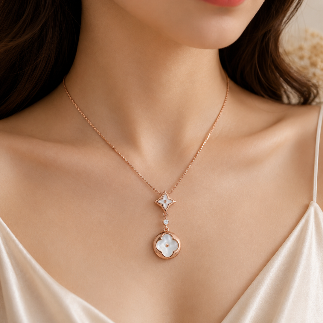 Rose gold necklace with floral pendant on a model wearing a white dress