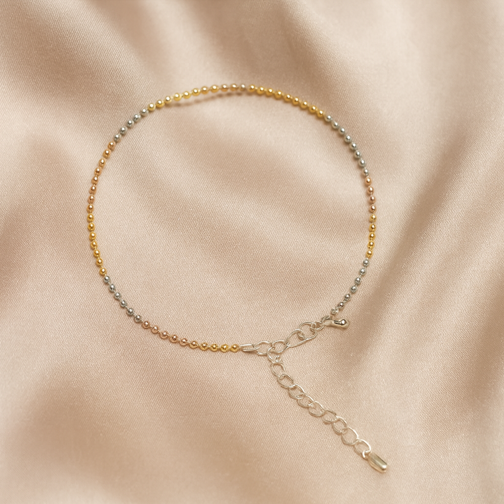 Anklet with multicolored beads on a beige fabric background