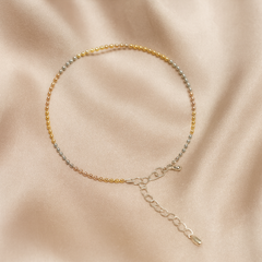 Anklet with multicolored beads on a beige fabric background