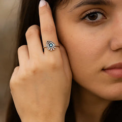 Close-up of a woman wearing a decorative ring on her finger.