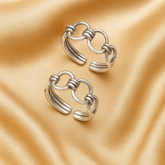Pair of silver hoop earrings on a beige fabric background