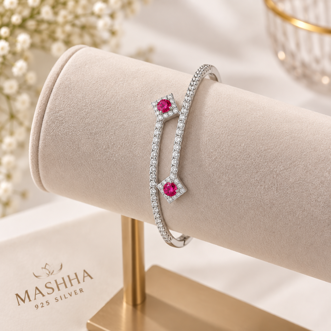 Silver bracelet with pink gemstones on a white background
