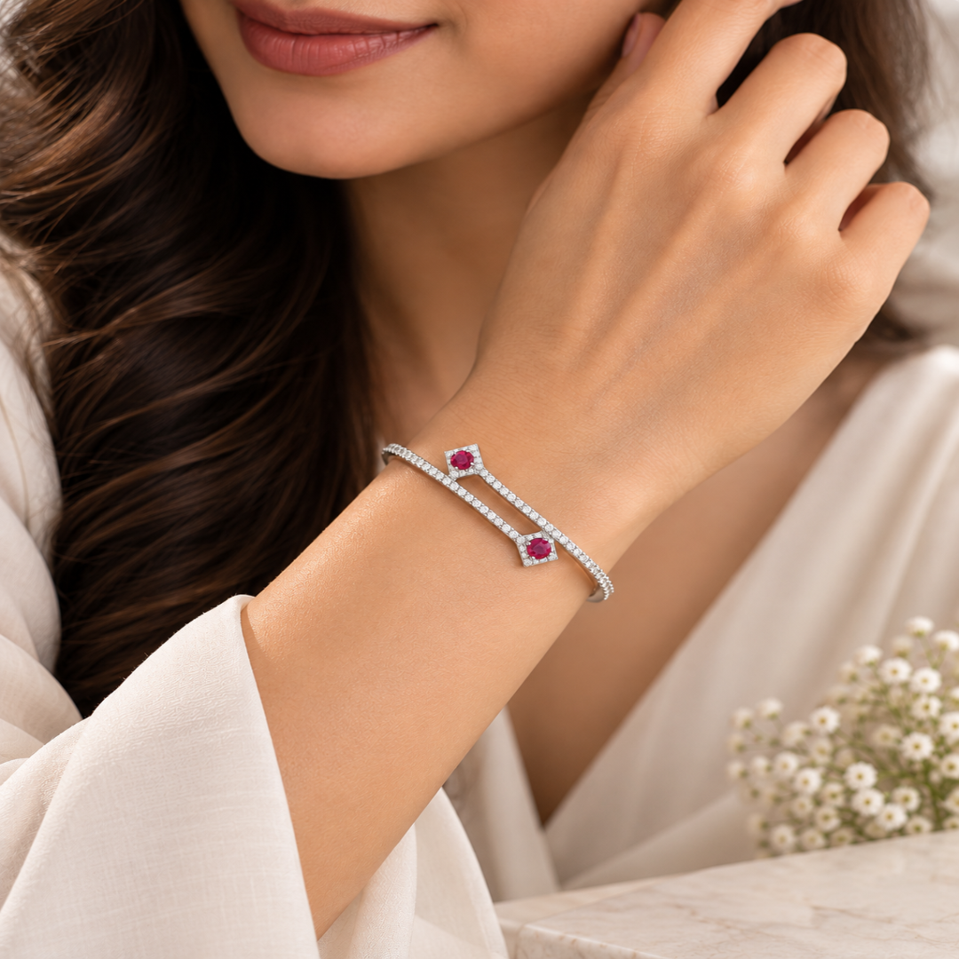 Silver bracelet with pink gemstones on a white background