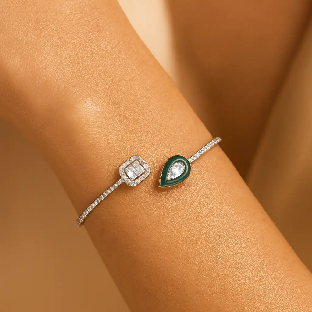 Two diamond-encrusted bracelets on a person's wrist against a beige background