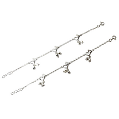 Silver bracelet with heart and bow charms on a white background