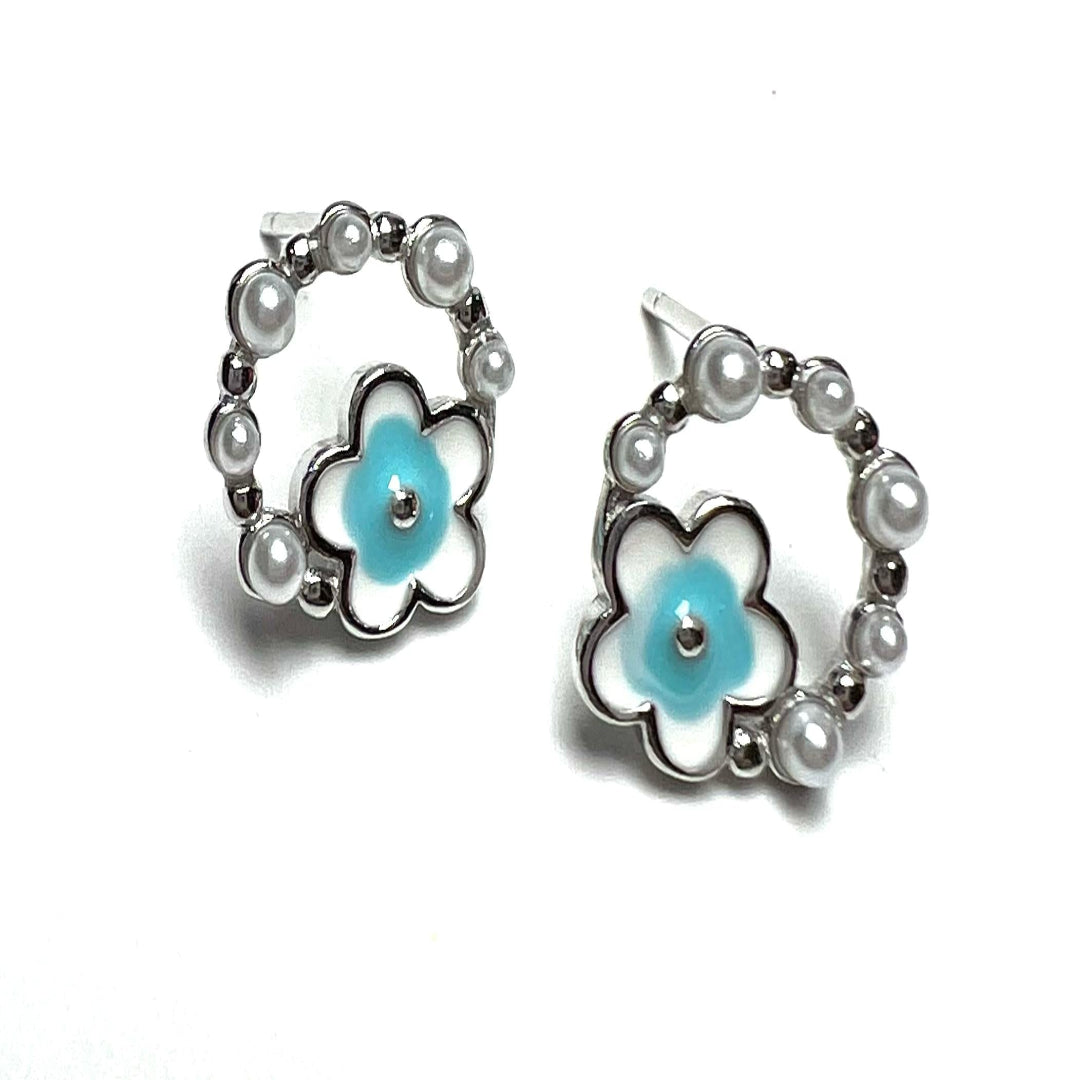 Pair of earrings with floral design and pearl accents on a white background