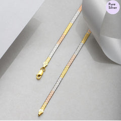 Three-colored silver and gold bracelet on a light gray background