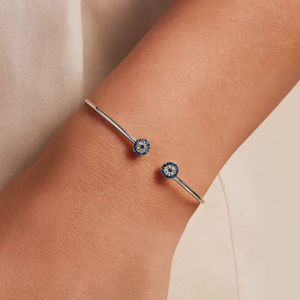 Silver bracelet with blue gemstones on a wrist against a beige background