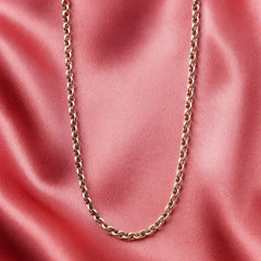 Gold chain necklace on a pink satin background